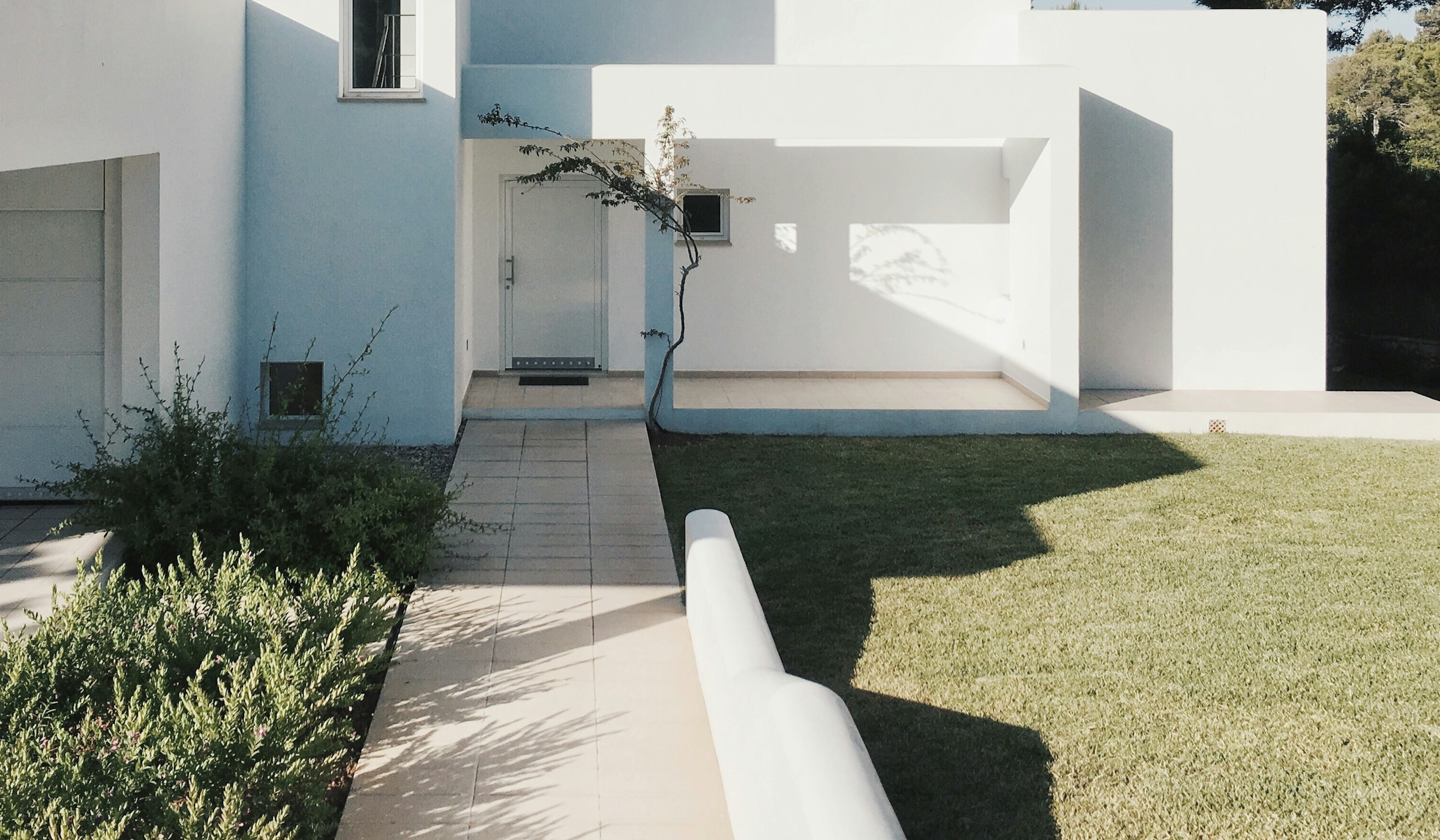 Minimalist architecture with a landscaped garden path leading to the entrance.