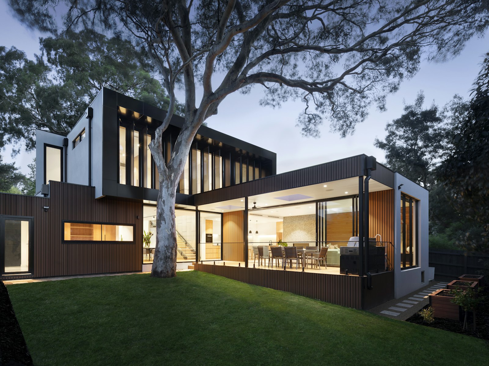Building facade framed by mature trees and lawn.